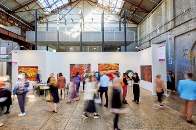 An airy gallery with out-of-focus visitors moving through it.