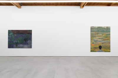 View of an art gallery showing two paintings hanging on the wall.